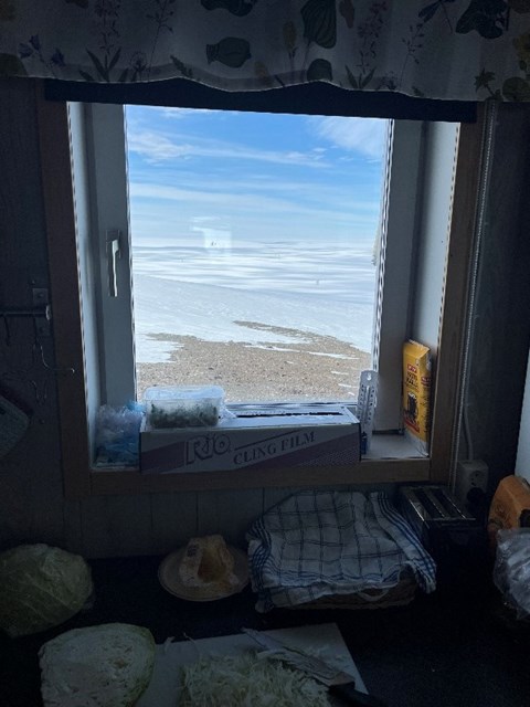 Through a window you can see miles of glaciers and blue sky.