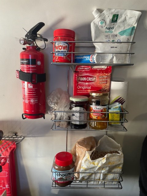 Food supplies on wall shelves inside the ark, also a fire extinguisher