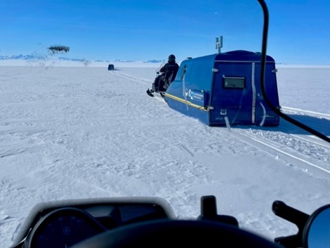 Snowmobile transporting an arc.